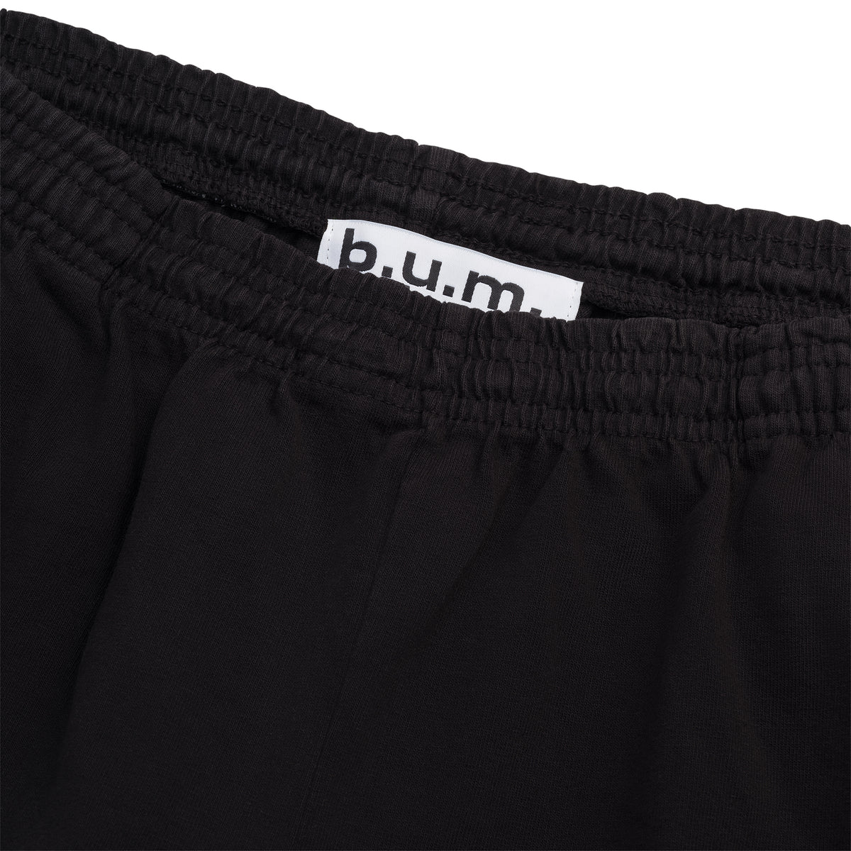 Detail of the B.U.M. Equipment black cotton shorts, showing the elastic drawstring waistband